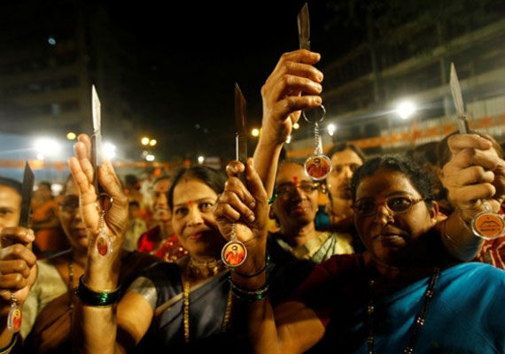 Donne dello Shiv Sena brandiscono i caratteristici coltelli effigianti il volto del leader Balasaheb Thackeray. Fonte: indiatvnews.com